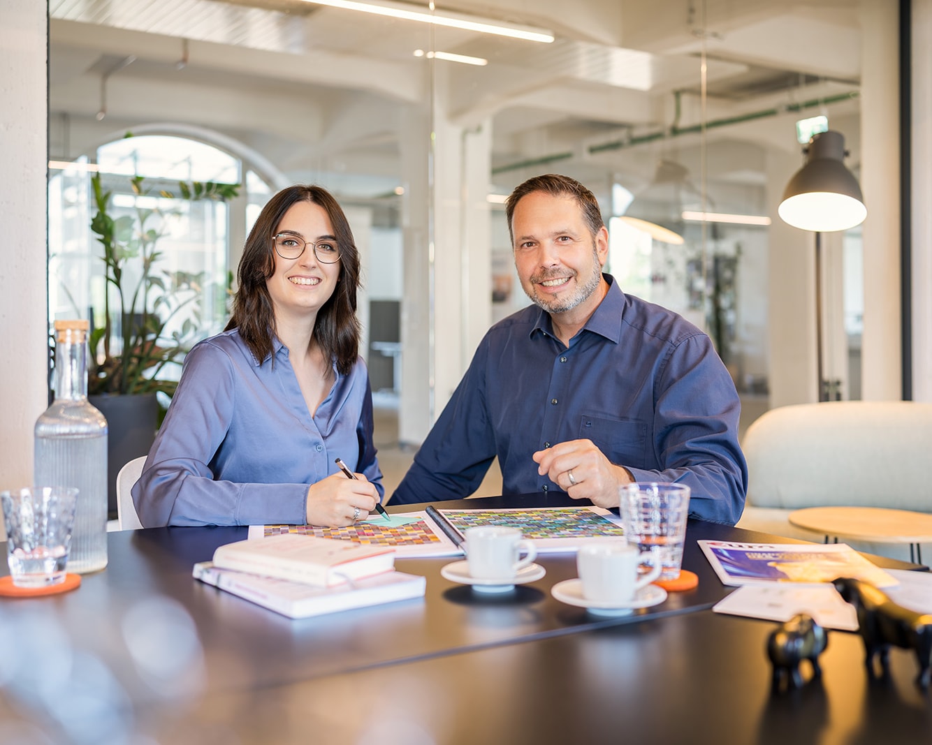 Stefan und Milena Lahmeyer am Besprechungstisch im Büro, vor sich Unterlagen und eine farbige Auswertung